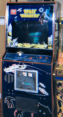 A blue arcade cabinet with a screen surrounded by decals. The game controls sit below the screen, while the phrase 